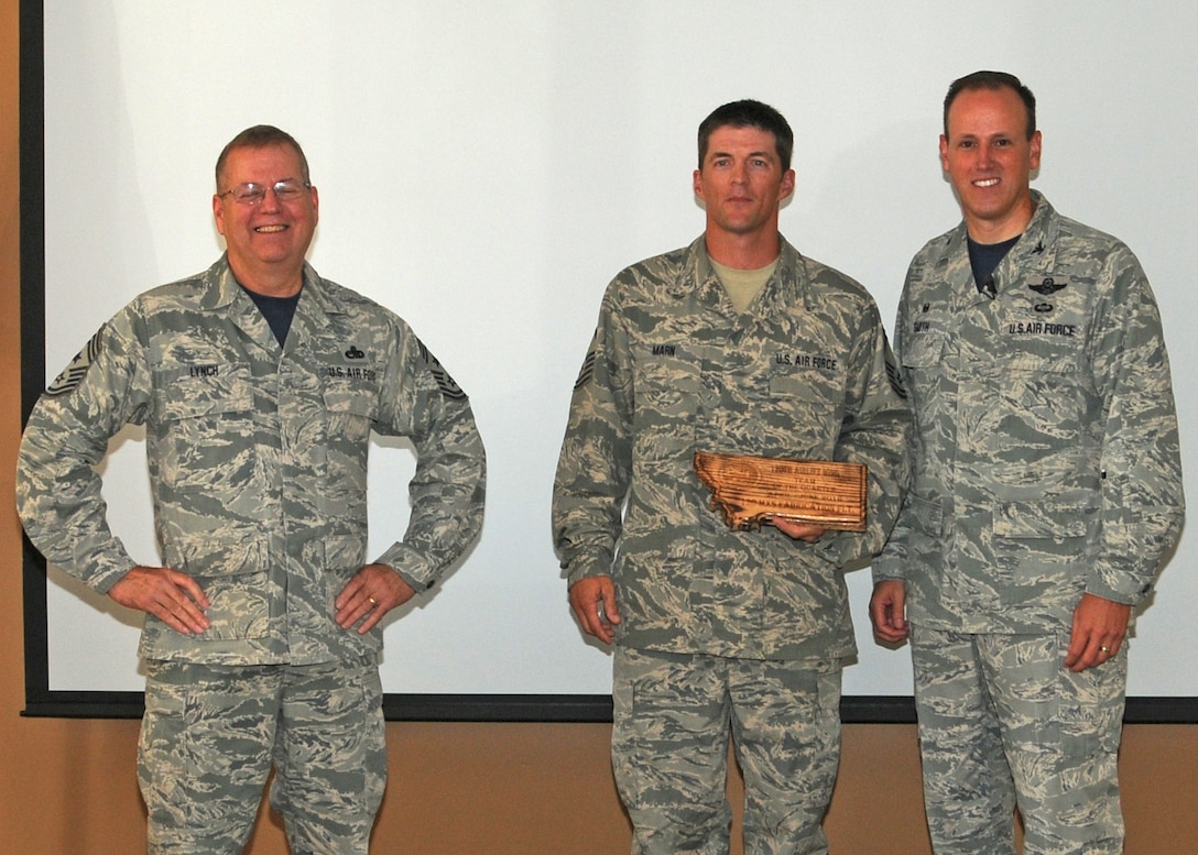Senior Master Sgt. Jeremy Marn accepts the Team of the Quarter Award from 120th Airlift Wing Commander Col. Lee Smith and 120th AW Command Chief, Chief Master Sgt. Steven Lynch, during a commander’s call held in the Larsen Room of the Wing Headquarters Building during the regularly scheduled drill August 13, 2016. (U.S. Air National Guard photo by Staff Sgt. Lindsey Soulsby)