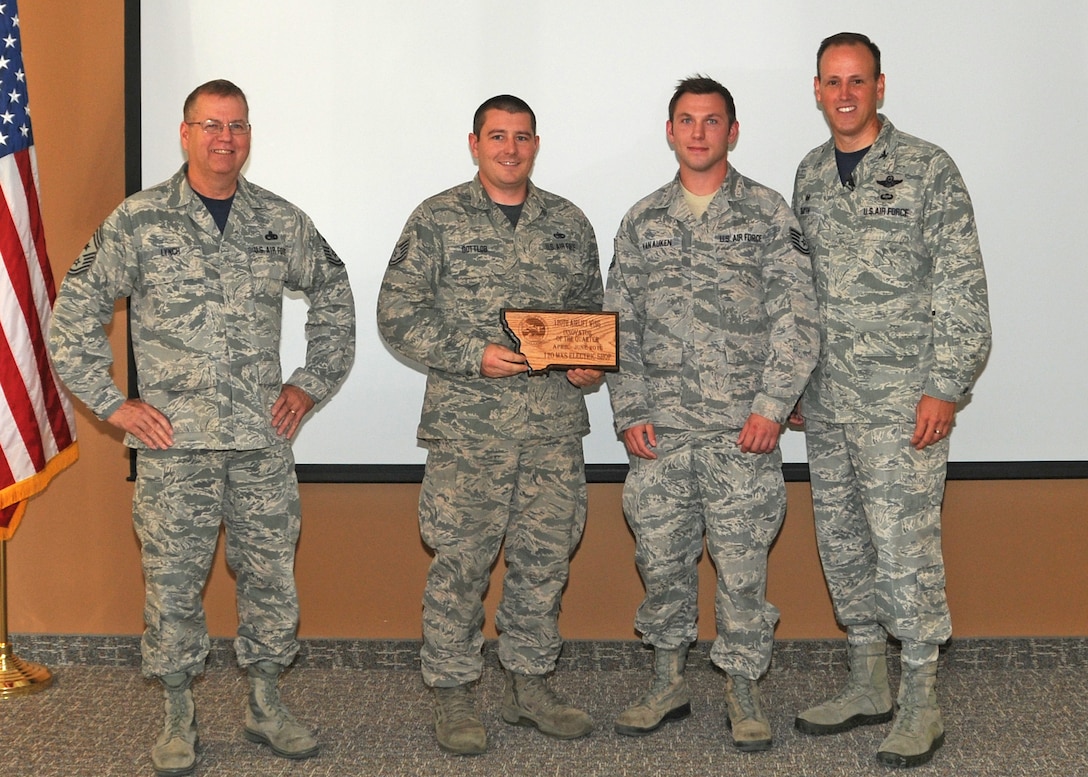 120th Airlift Wing Commander Col. Lee Smith and 120th AW Command Chief, Chief Master Sgt. Steven Lynch, present the Innovator of the Quarter Award to Tech. Sgts. Keith Gottlob and Ronald Van Auken during a commander’s call held in the Larsen Room of the Wing Headquarters Building during the regularly scheduled drill August 13, 2016. (U.S. Air National Guard photo by Staff Sgt. Lindsey Soulsby) 