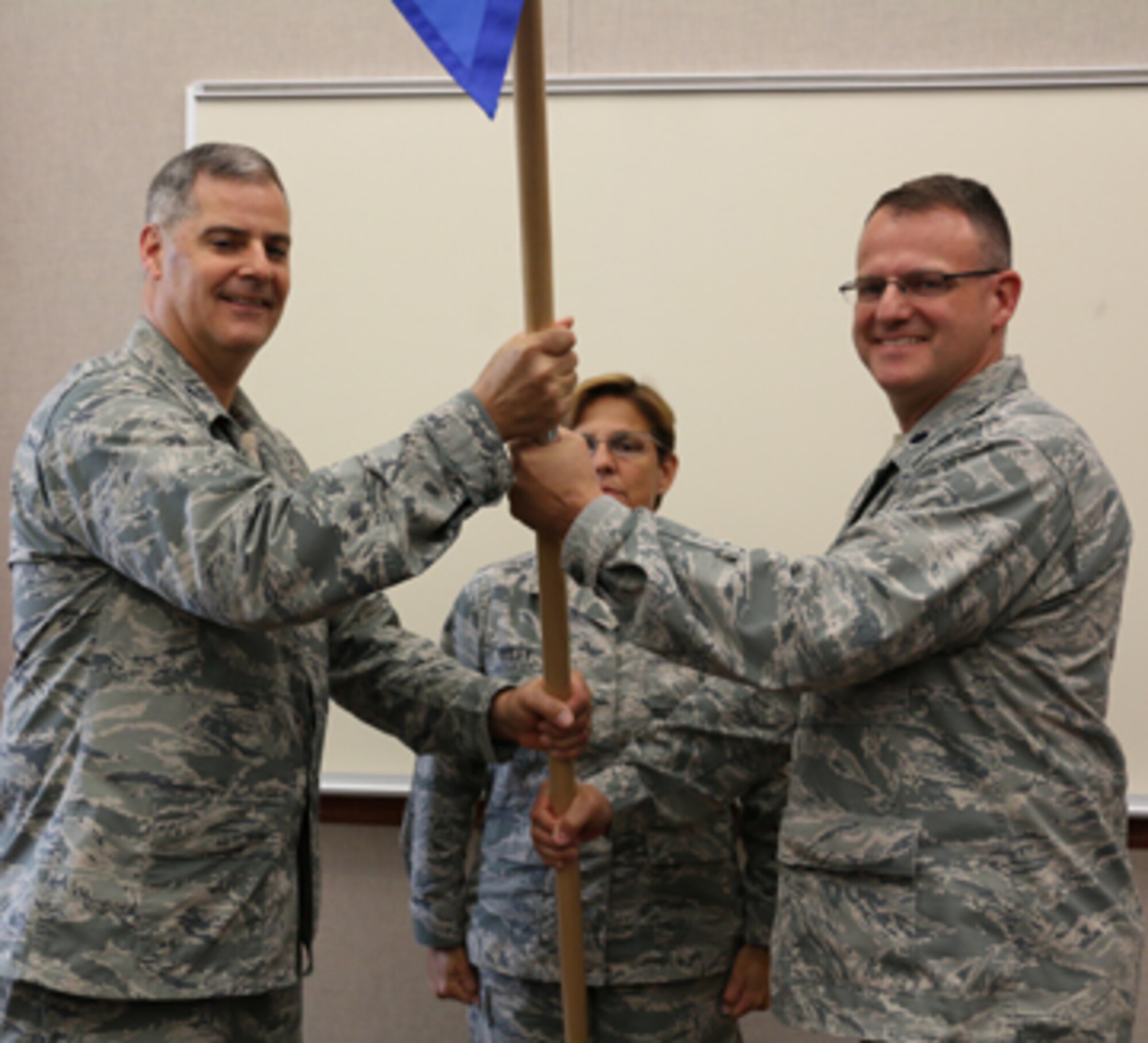 Lt. Col. David Bartczak, right, takes the guidon from 224th Air Defense Group Commander Col. John Balbierer during the Aug. 18 Support Squadron assumption of command ceremony at the Eastern Air Defense Sector. Chief Master Sgt. Maureen Dooley, the Senior Enlisted Advisor at the 224th ADG, is in the back. 