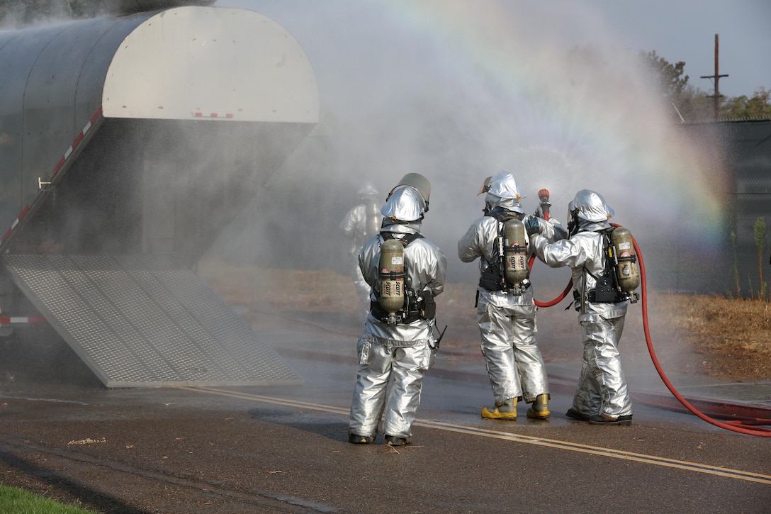 Marines with Aircraft Rescue and Firefighting douse a simulated aircraft with water during an aircraft mass casualty exercise aboard Marine Corps Air Station Miramar, Calif., Aug. 24. Marines with ARFF and firefighters with the MCAS Miramar Fire Department worked alongside San Diego first responders to improve response times, solidify existing standard operating procedures for emergencies and fulfill annual training requirements. (U.S. Marine Corps photo by Pfc. Jake M.T. McClung/Released)