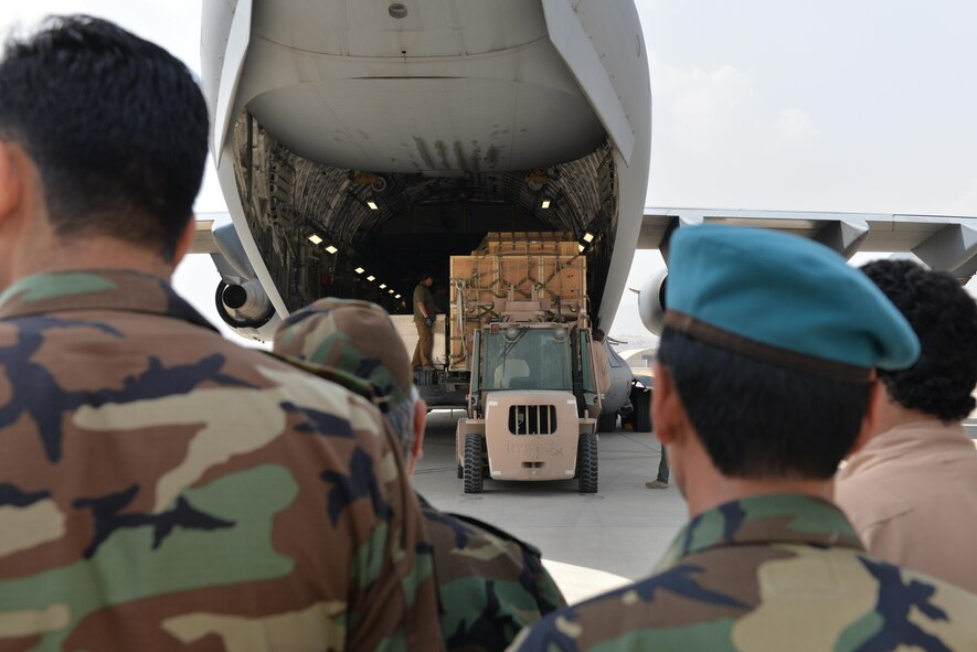 Members of the Afghan air force watch as crates are unloaded from a C-17 Globemaster III from Travis Air Force Base, Calif., at Hamid Karzai International Air Port, Kabul, Afghanistan, Aug. 25, 2016. The crates contained ramps that were used to unload four MD-530 Cayuse Warrior helicopters. The helicopters are the last ones to be delivered to the AAF, bringing their total number to 27. (U.S. Air Force photo by Tech. Sgt. Christopher Holmes) 