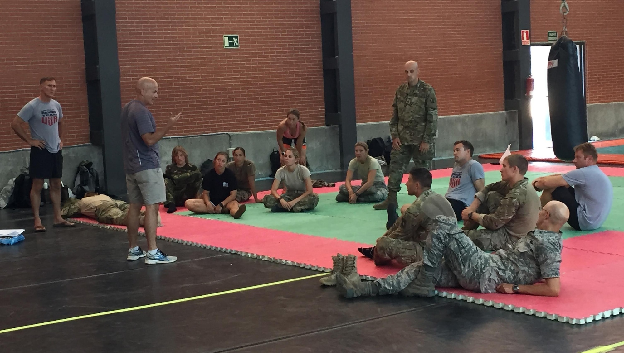 After an exhausting day on the land obstacle course, Lt. Col. Daryl Remick (center, standing) former competitor, Georgia Army National Guard and full-time emergency room physician, teaches Tactical Combat Casualty Care, ably assisted by Staff Sgt. Reuben Sublett (standing right), Army Reserve Medic.