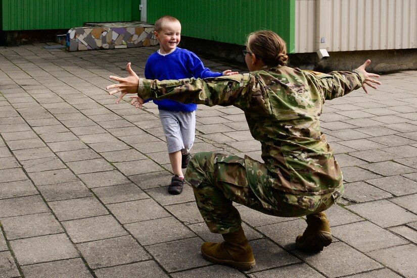 U.S. Army Spc. Stephanie Lish, assigned to Alpha Company, 457th Civil Affairs Battalion, 361st Civil Affairs Brigade, 7th Mission Support Command, prepares to hug a child from Kudikiu Namai during a Humanitarian Civil Assistance (HCA) project, in Sauliai, Lithuania, August 23, 2016. As part of the European Command’s (EUCOM) Humanitarian and Civic Assistance Program, the 375th Engineer Company, 457th Civil Affairs Battalion and the Lithuanian military collaborate to renovate the fence at Kudikiu Namai, an orphanage for Lithuanian children up to the age of 6, in Sauliai, Lithuania, August 8-26, 2016. (U.S. Army Photo by Pfc. Emily Houdershieldt)