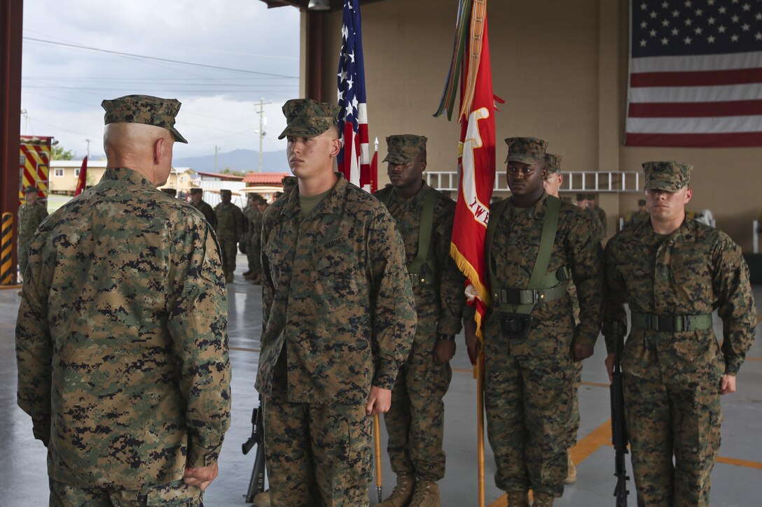 Commandant of the Marine Corps Gen. Robert B. Neller, left, stands at the position of attention during the award ceremony for Lance Cpl. Duncan Harris, automotive maintenance technician, at Soto Cano Air Base, Honduras, Aug. 21, 2016. Harris was awarded the Navy and Marine Corps Medal for saving a child from drowning. (U.S. Marine Corps photo by Cpl. Samantha K. Braun/Released)