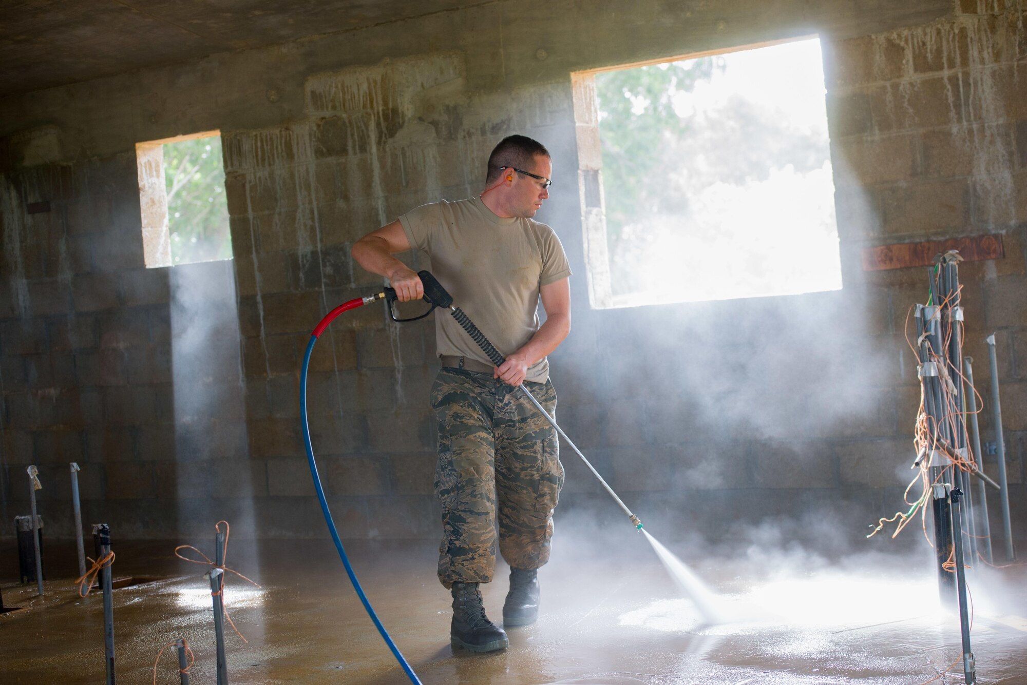 Tech. Sgt. Justin Gooden, a 134th Air Refueling Wing engineering apprentice, power washes the interior of a home in Malojloj, Guam, in preparation of interior construction. Airmen of the 134th ARW work on two Habitat for Humanity homes in Guam as part of a government initiative that allows military assets the opportunity to assist non-profit organizations in conjunction with scheduled annual training. (U.S. Air National Guard photo/Tech. Sgt. Jonathan Young)