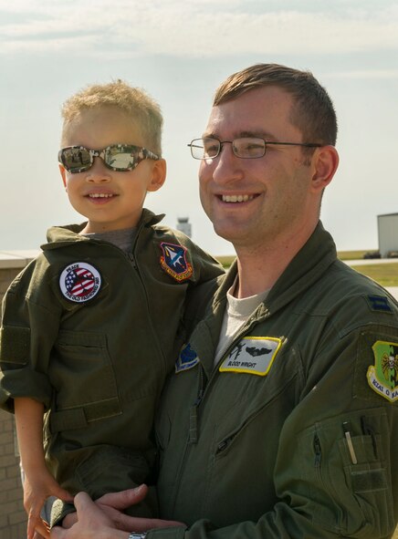 Capt. Samuel Wright, 69th Bomb Squadron assistant flight commander, holds his son during a welcome home event at Minot Air Force Base, N.D., Aug. 23, 2016. The six-month deployment was the unit’s last to Andersen AFB, Guam before they begin supporting Central Command’s mission in the Middle East. (U.S. Air Force photo/Senior Airman Apryl Hall)