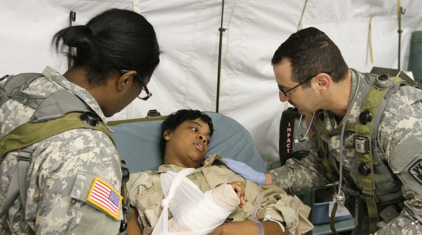 FORT MCCOY, Wis -- Capt. Traci Kelley (left), a public health nurse from the 75th Combat Support Hospital out of San Antonio, Texas, and 1st. Lt. Charles Binder (right), a medical-surgical nurse from the 75th Combat Support Hospital out of San Antonio, Texas, both check the responsiveness of an Army Reserve Soldier simulating a wounded patient during the Global Medic Exercise at Fort McCoy, Wis. on Aug. 20, 2016. Global Medic is an inter-service training event that develops and evaluates the collective skills of Army Reserve Soldiers and other service members in a collaborative environment. (U.S. Army Reserve photo by Spc. Christopher A. Hernandez, 345th Public Affairs Detachment)