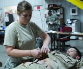 FORT MCCOY, Wis -- Sgt. Sarah Anderson, a practical nursing specialist from the 5501st U.S. Army Hospital out of San Antonio, Texas, treats a simulated wound on Pfc. Joshua Tanner, a practical nursing specialist from the 75th Combat Support Hospital out of Tuscaloosa, Ala., during the Global Medic Exercise at Fort McCoy, Wis. on Aug. 19, 2016. Global Medic is an inter-service training event that develops and evaluates the collective skills of Army Reserve Soldiers and other service members in a collaborative environment. (U.S. Army Reserve photo by Spc. Christopher A. Hernandez, 345th Public Affairs Detachment)