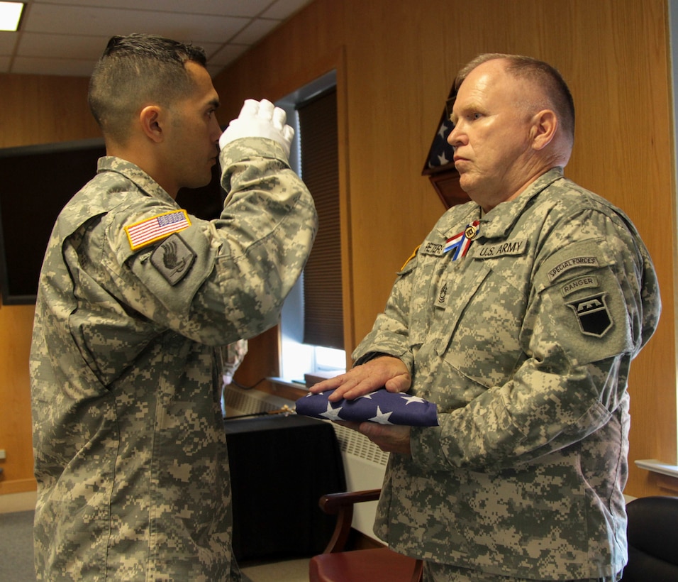 The Color Bearer presents the pre-folded flag to retired Sgt. Maj. Stephen Peters, during a retirement ceremony held Sunday at Fort Douglas, Utah.