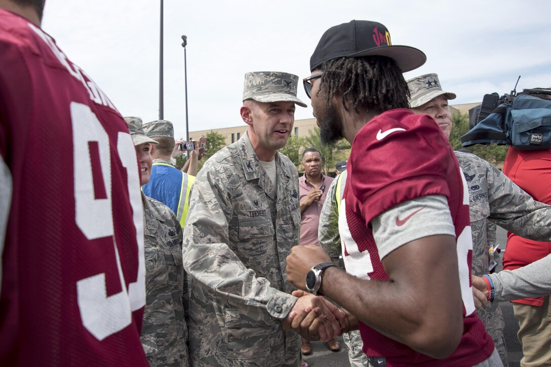 Col. E. John Teichert greets Josh Norman, Washington Redskins cornerback, during a preseason walk-through at Joint Base Andrews, Md., Aug. 25, 2016. The practice was followed by an autograph meet and greet with fans as a way for the Redskins to show their appreciation for the men and women of the armed forces. (U.S. Air Force Photo by Airman Gabrielle Spalding)