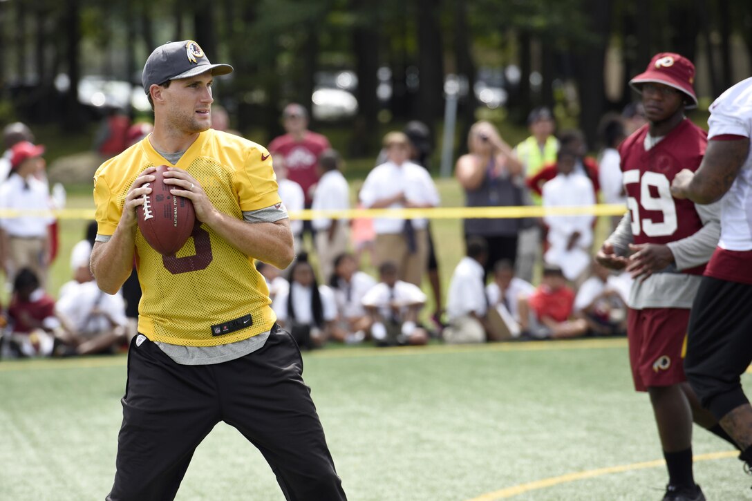 Kirk Cousins, Washington Redskins quarterback, prepares to throw a football during a preseason walk-through practice at Joint Base Andrews, Md., Aug. 25, 2016. The practice was followed by an autograph meet and greet with fans as a way for the Redskins to show their appreciation for the men and women of the armed forces. (U.S. Air Force Photo by Airman Gabrielle Spalding)