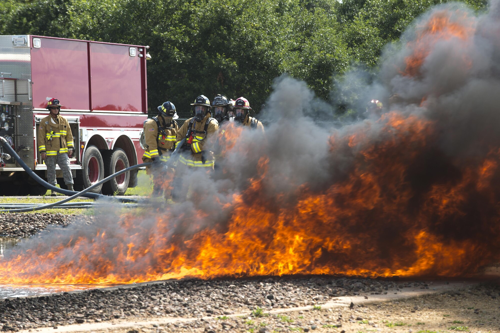 Air Force Reserve firefighters wait for the fuel-fire to build in size before they extinguish it during exercise Patriot Warrior Aug. 18, 2016, Sparta/Fort McCoy Airport, Wis. Patriot Warrior allows Air Reserve firefighting units from throughout the U.S. to train together and learn from professionals throughout the career field in a deployment-style environment. (U.S. Air Force Photo/ Tech. Sgt. Nathan Rivard)