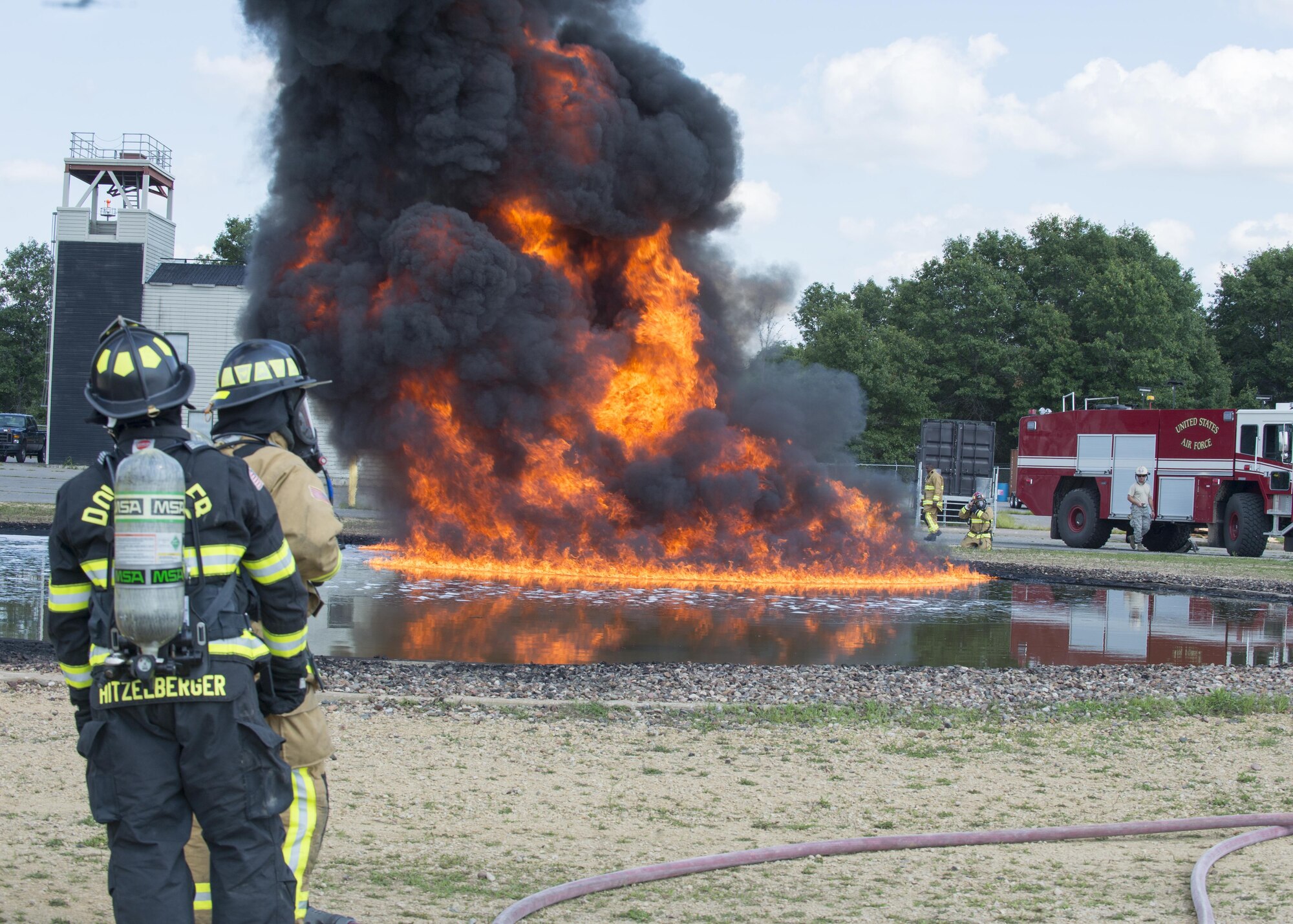 Air Force Reserve firefighters wait for the fuel-fire to build in size before they extinguish it during exercise Patriot Warrior Aug. 18, 2016, at Sparta/Fort McCoy Airport, Wis. Patriot Warrior allows Air Force Reserve firefighting units from throughout the U.S. to train together and learn from professionals throughout the career field in a deployment-style environment. (U.S. Air Force Photo/Tech. Sgt. Nathan Rivard)