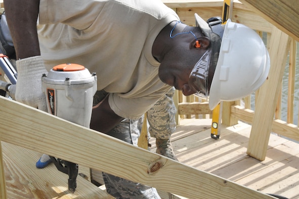 Tech. Sgt. David Morrison, a Civil Engineer structural engineer, uses a nail gun to secure a piece of treated lumber to the new staircase leading from the Veteran’s Park to the riverside here, Aug. 25, 2016. Morrison is a member of a small team from the 910th Civil Engineer Squadron, based at nearby Youngstown Air Reserve Station (YARS), Ohio, who teamed up with the City of Newton Falls to undertake a three-week project to demolish the existing staircase and design and build the new stairs under Department of Defense’s Realistic Military Training program and the Air Force Community Partnership Program. The program is designed to identify and develop mutually beneficial partnerships between Air Force installations and surrounding communities. (U.S. Air Force photo/Master Sgt. Bob Barko Jr.)
