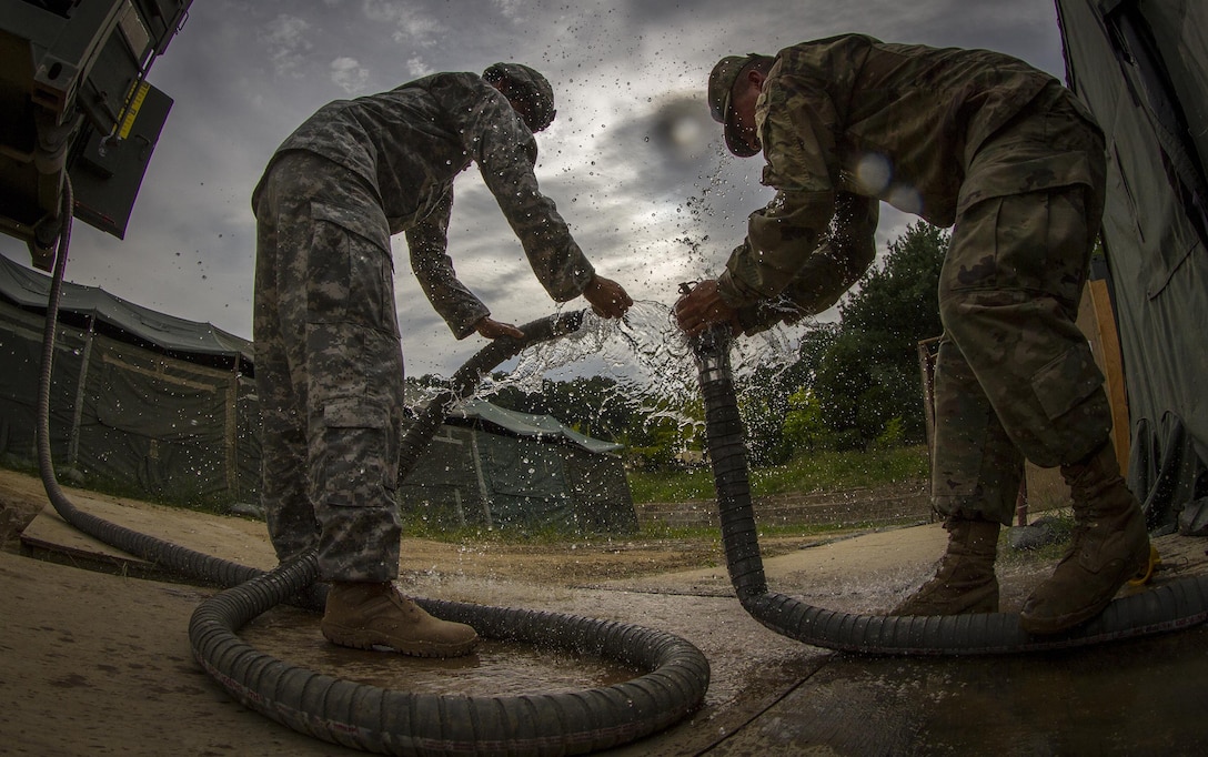 U.S. Army Private 1st Class Andrew Skalecki, from Kansasville, Wi., and Spc. Jose Rodriquez of San Juan, Puerto Rico - both water treatment specialists with the 339th Quartermaster Co. - resupply the water for over 500 U.S. and Canadian soldiers staying in a tent village at Yongin, South Korea, from an LHS vehicle carrying 2,000 gallons of water, Aug. 25, 2016. (U.S. Army photo by Staff Sgt. Ken Scar)