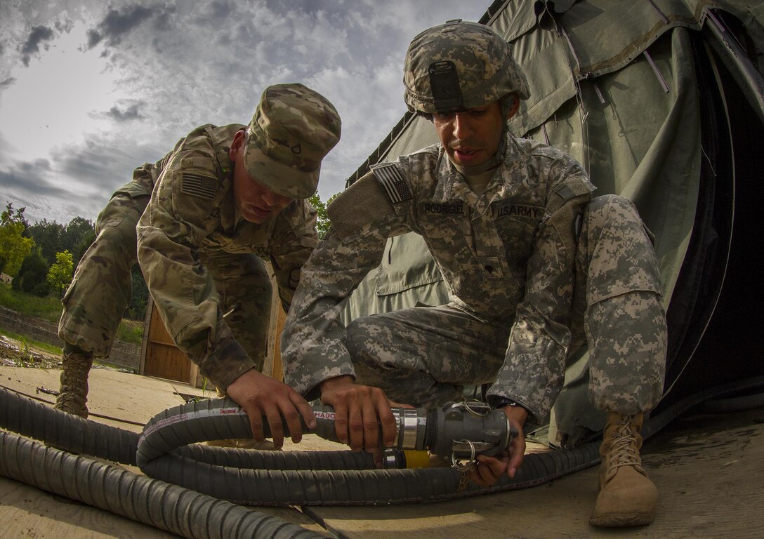 U.S. Army Private 1st Class Andrew Skalecki, from Kansasville, Wi., and Spc. Jose Rodriquez of San Juan, Puerto Rico - both water treatment specialists with the 339th Quartermaster Co. - resupply the water for over 500 U.S. and Canadian soldiers staying in a tent village at Yongin, South Korea, from an LHS vehicle carrying 2,000 gallons of water, Aug. 25, 2016. (U.S. Army photo by Staff Sgt. Ken Scar)