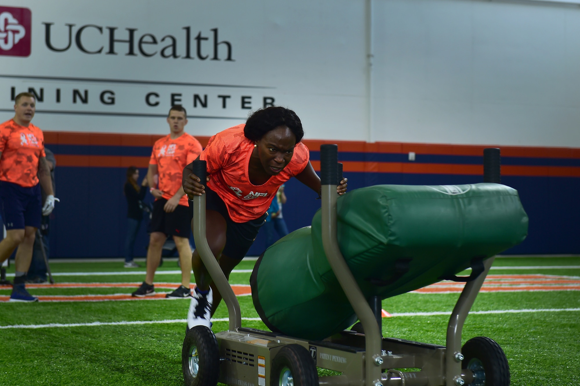 Staff Sgt. Jocquise Wolfe, 460th Space Wing command post operator, participates in a sled push portion of a military training camp at the Denver Broncos’ University of Colorado Health Training Center Fieldhouse in Englewood, Colo., August 25, 2016. Team Buckley won the military camp competition after participating in five head-to-head challenges including: team ball catching, a gauntlet, tackling dummy relay, sled push and the kneeling power ball launch. (U.S. Air Force photo by Airman 1st Class Gabrielle Spradling/Released)
