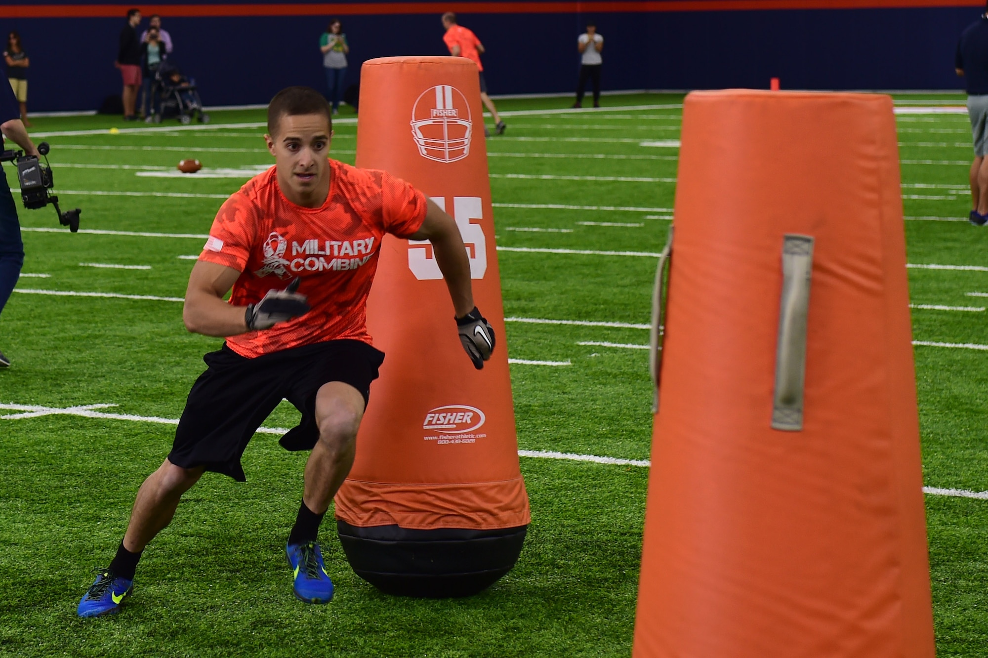 1st Lt. James Macandrew, 460th Space Wing Commanders Action Group chief, runs through tackling dummies during the five-man obstacle course of a military training camp at the Denver Broncos’ University of Colorado Health Training Center Fieldhouse in Englewood, Colo., August 25, 2016. Team Buckley won the military camp competition after participating in five head-to-head challenges including: team ball catching, a gauntlet, tackling dummy relay, sled push and the kneeling power ball launch. (U.S. Air Force photo by Airman 1st Class Gabrielle Spradling/Released)