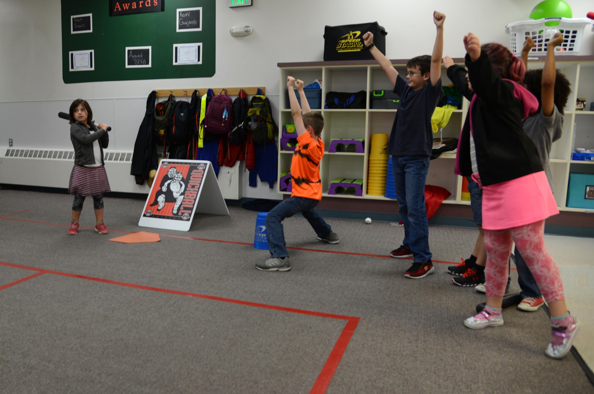 Samantha McCulloch, 6, prepares to hit a ball in a game of Quickball as her teammates cheer her on at the Ketchikan School Age Center on Joint Base Elmendorf-Richardson Aug. 25. Quickball is a game that is part of the Science, Technology, Engineering and Math program at JBER’s school age centers and youth centers. STEM is an initiative under the Sea Research Foundation to promote student achievement and preparation for global competitiveness by fostering educational excellence and ensuring equal success. (U.S. Air Force photo by Staff Sgt. Wes Wright)