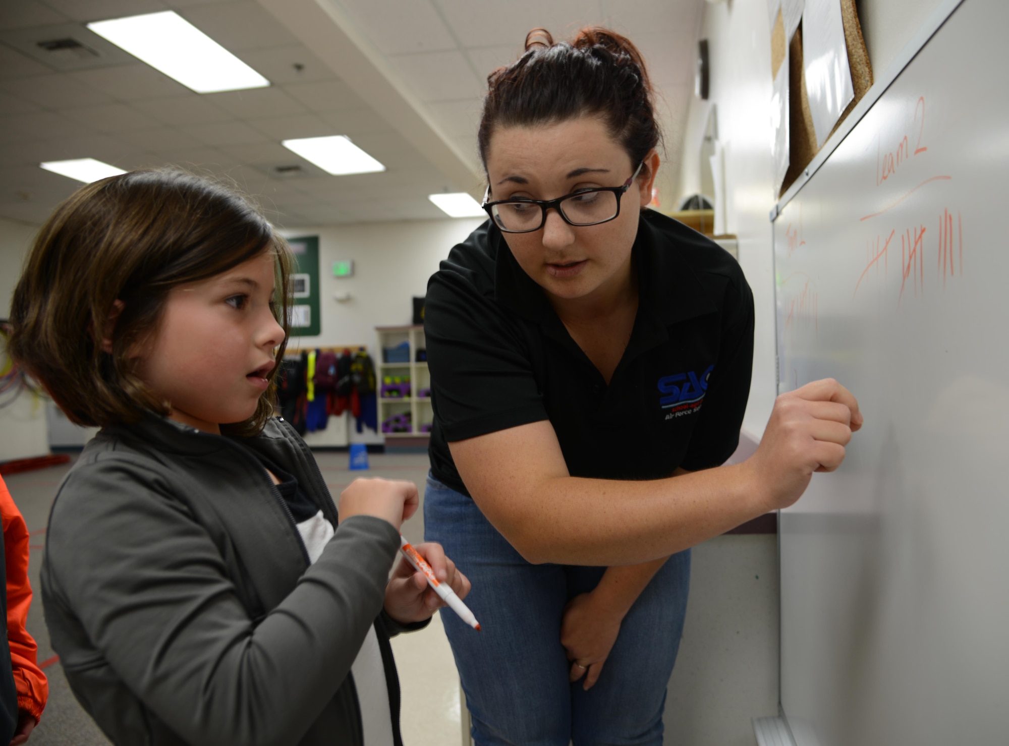 Beth Yost, Child and Youth program assistant at Ketchikan School Age Center, teaches Samantha McCulloch, 6, how to use tally marks following a game of Quickball Aug. 25. Quickball is a game that is part of the Science, Technology, Engineering and Math program at JBER’s school age centers and youth centers. STEM is an initiative under the Sea Research Foundation to promote student achievement and preparation for global competitiveness by fostering educational excellence and ensuring equal success. (U.S. Air Force photo by Staff Sgt. Wes Wright)