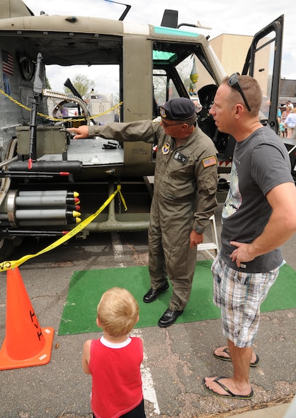 Master Sgt. Daniel Belk (right), 302nd Maintenance Squadron quality assurance, and his son, Daniel Lee Belk Jr. are given a tour of the UH-1 (M) ‘Huey’ by retired Chief Master Sgt. Bill Martin during the 302nd Airlift Wing Family Day on Aug. 6, 2016 here. During the August Unit Training Assembly, the 302nd AW honors families by hosting a family day for all wing members and their families. This year, there were a variety of activities in addition to the helicopter tours including bouncy houses, a fishpond, wheel of fortune, many tables with children’s games, and food for everyone. (U.S. Air Force photo/Staff Sgt. Amber Sorsek)