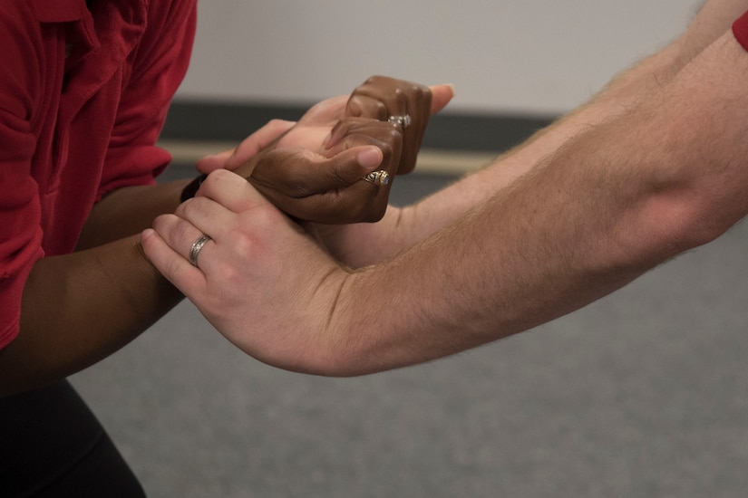 Staff Sgt. Shandralekha Carlos, 11th Wing Commander's Action Group NCO in charge, and Staff Sgt. Kevin Maeder, 11th Security Support Squadron security forces instructor, demonstrate how to break a wrist grab during a Rape Aggression Defense class at Joint Base Andrews, Md., Aug. 20, 2016. The R.A.D. class is a self-defense program teaching basic self-defense tactics and avoidance techniques for risk factors. (U.S. Air Force photo by Airman 1st Class Rustie Kramer)
