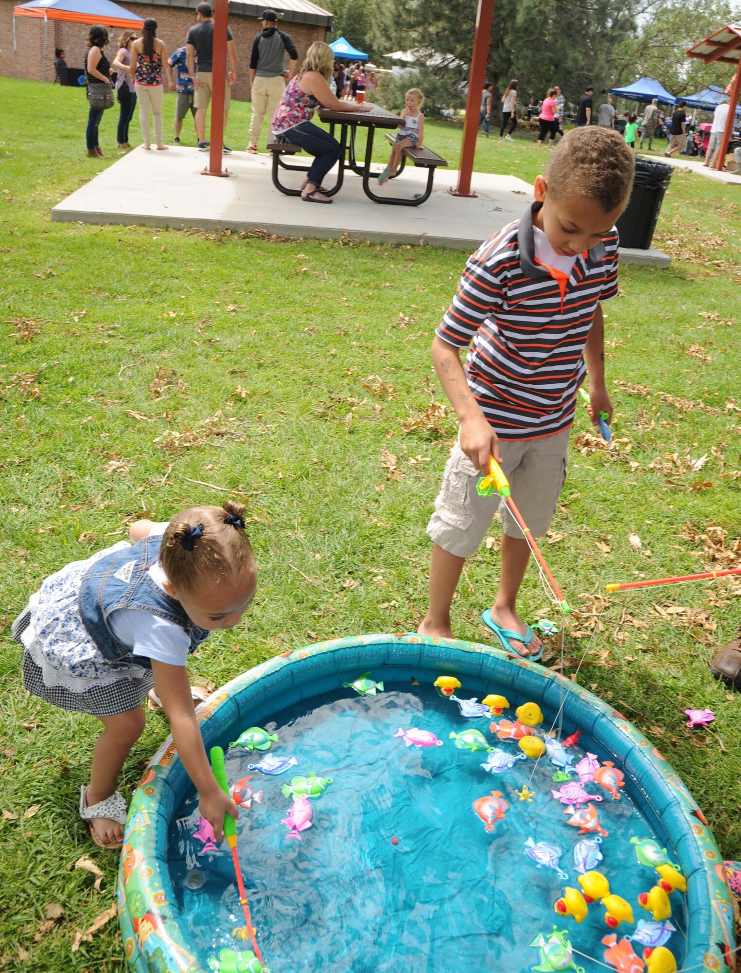 Rubi (left) and Sammy Kent try to catch fish and ducks for a prize at the fishpond during the 302nd Airlift Wing Family Day on Aug. 6, 2016 here. Every year the 302nd AW honors families by hosting a family day for all wing members and their families. This year, there were a variety of activities including bouncy houses, helicopter tours, wheel of fortune, many tables with children’s games, and food for everyone. (U.S. Air Force photo/Staff Sgt. Amber Sorsek)