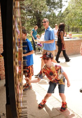 Jayden Lacey spins the wheel of fortune during the 302nd Airlift Wing Family Day on Aug. 6, 2016 here. Every year the 302nd Airlift Wing honors families by hosting a family day for all wing members and their families. This year, there were a variety of activities including bouncy houses, a fishpond, helicopter tours, many tables with children’s games, and food for everyone. (U.S. Air Force photo/Staff Sgt. Amber Sorsek)