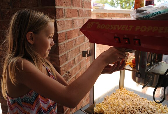 Dominique Bonnin volunteers to make popcorn for 302nd Airlift Wing members and their families during the annual Family Day on Aug. 6, 2016 here. This annual event allows wing members to show their appreciation to their families with an afternoon of fun activities and food. (U.S. Air Force photo/ Staff Sgt. Amber Sorsek)