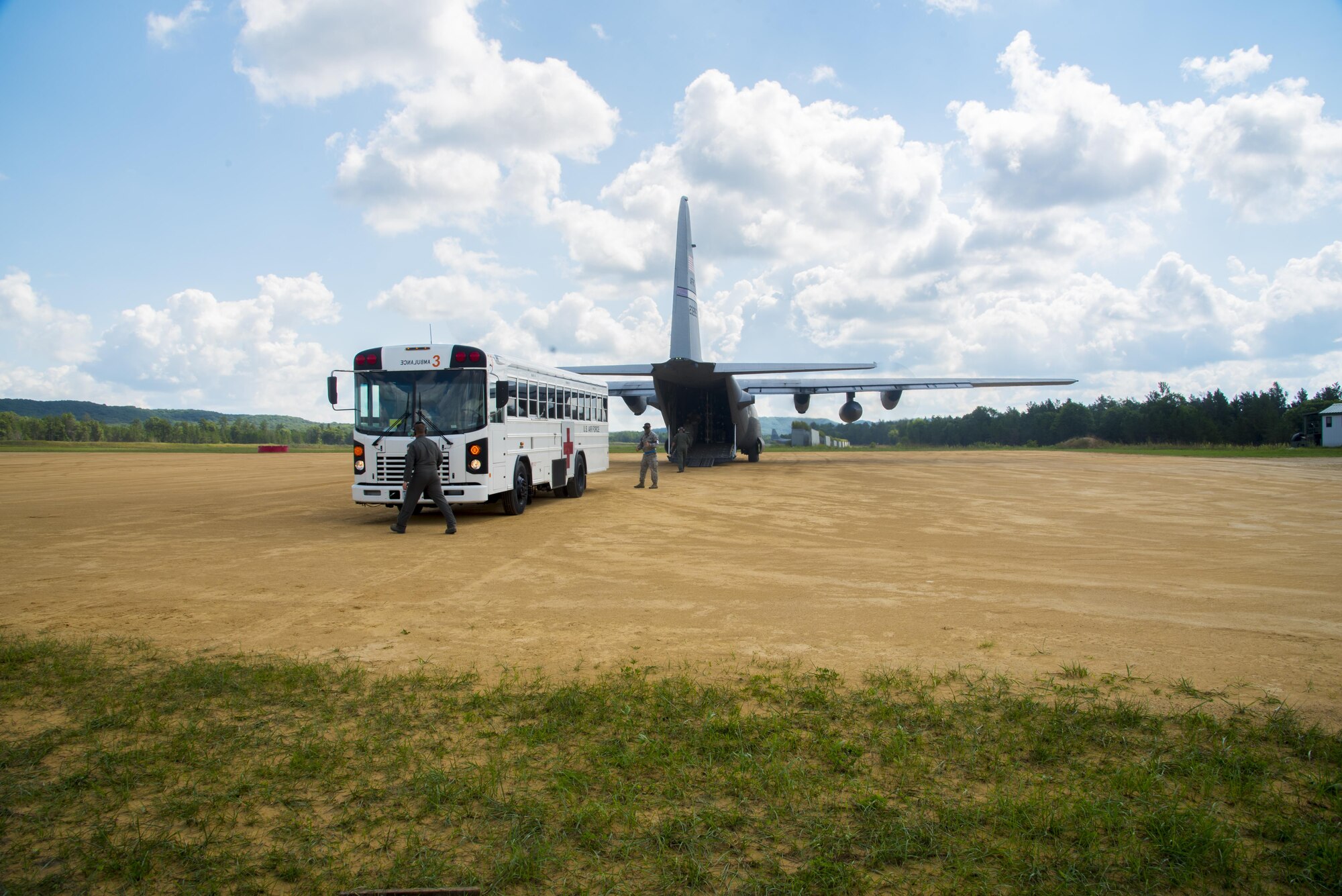 Air Force medical patient bus sits in front of C-130 Hercules preparing for an off load of simulated patients during Patriot Warrior exercise August 16, 2016, at Fort McCoy, Wis. Patriot Warrior is the Air Force Reserve's premier contingency deployment training exercise, designed to demonstrate training ranging from bare base buildup to full operational capabilities. (U.S. Air Force photo by Staff Sgt. Adam C. Borgman)