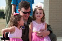 A 69th Bomb Squadron aircrew member holds his two daughters after returning from a deployment at Andersen Air Force Base, Guam, on the flight line at Minot Air Force Base, N.D., Aug. 23, 2016. The aircrew was on a mission to support the continuous bomber presence. (U.S. Air Force photo/Airman 1st Class Jonathan McElderry)