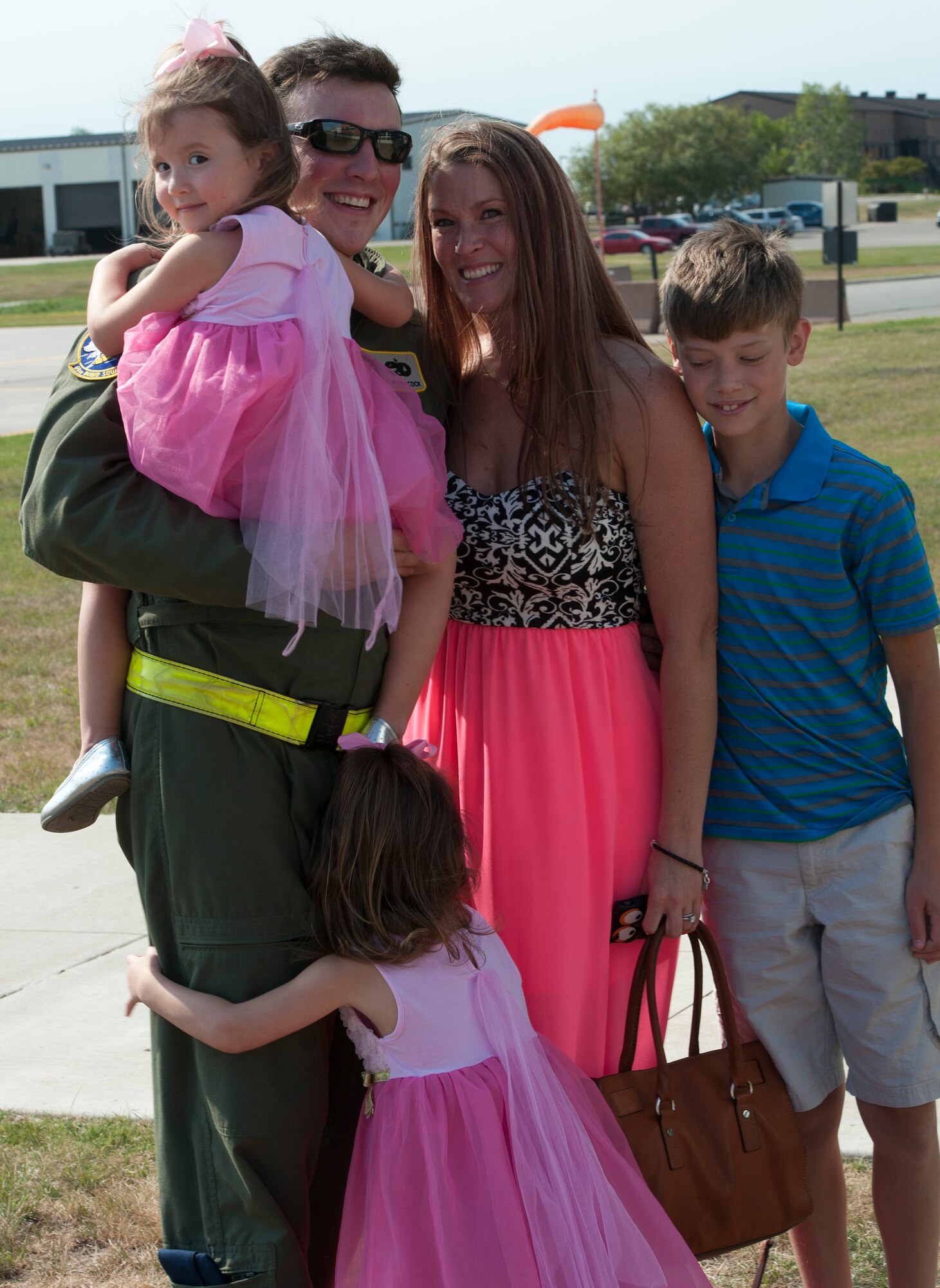A 69th Bomb Squadron aircrew member poses for a photo with his family on the flight line at Minot Air Force Base, N.D., Aug. 23, 2016. The 5th Bomb Wing will begin supporting the Central Command mission out of Al Udeid Air Base. (U.S. Air Force photo/Airman 1st Class Jonathan McElderry)