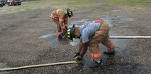 5th Civil Engineer Squadron firefighters roll up fire hoses after their training exercise at the fire department training pit at Minot Air Force Base, N.D., Aug. 24, 2016. Most firefighters only go through one rotation of the exercise, but some will go through it again if necessary. (U.S. Air Force photo/Airman 1st Class Jonathan McElderry)