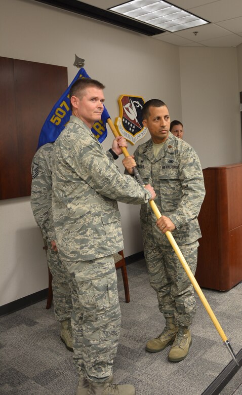 Lt Col. Gregg Russell, deputy commander 507th Mission Support Group, passes the 507th Logistics Readiness Squadron guidon to Maj. Damien C. Miller during an assumption of command ceremony at Tinker Air Force Base, Aug. 6, 2016. (U.S. Air Force photo/Master Sgt. Grady Epperly)