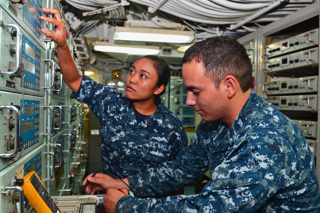 Navy Petty Officer 2nd Class Laura A. Hale and Petty Officer 3rd Class Martin Rodriguez do troubleshooting work in the radio room aboard the USS Bataan in Norfolk, Va., Aug. 18, 2016. Hale is an information systems technician; Rodriguez is an electronics technician. Navy photo by Seaman Apprentice Zachariah Grabill 
