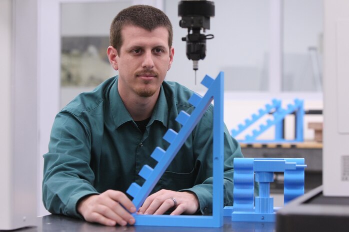 Vincent J. Capobianco, an NSWC Corona Division engineer, pictured with artifacts on a coordinate measurement machine (CMM), as illustration for story about his Naval Innovative Science and Engineering (NISE) project to develop calibration standards for 3-D printers. 