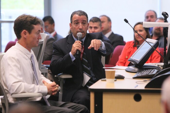 Dan Deconzo, NSWC Corona Division small business deputy, holding microphone, moderates panel discussion during Industry Partnership Forum at Norco College. The event, organized in cooperation with Riverside Community College District Procurement Assistance Center, included a forecast of NSWC Corona future contracting/subcontracting opportunities as well as a series of meet-and-greet sessions for suppliers to network with technical department personnel.