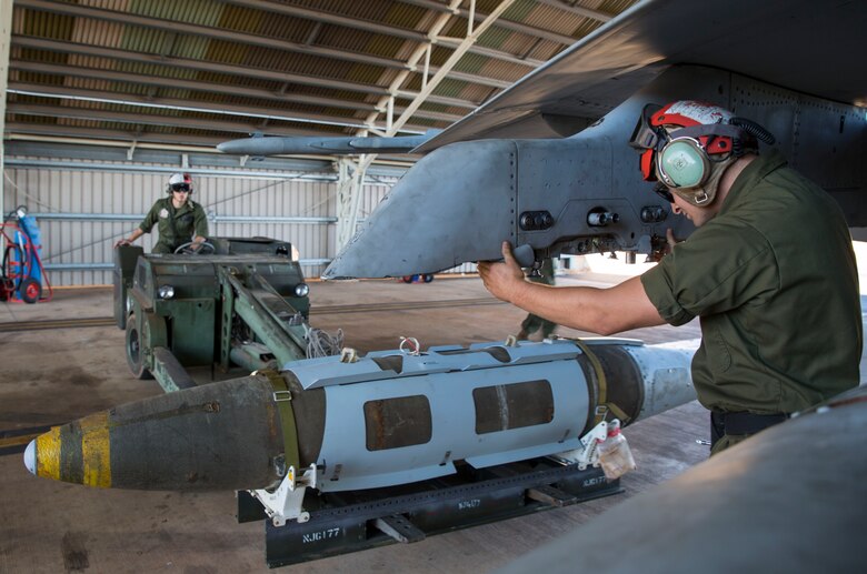 U.S. Marine Corps Lance Cpl. Trevor Serenelli, ordnance Marine assigned to Marine Fighter Attack Squadron (VMFA) 122, shouts directions while guiding a bomb onto an aircraft during Southern Frontier at Royal Australian Air Force Base Tindal, Australia, Aug. 26, 2016. VMFA-122 delivered munitions while providing close air support to ground combat units at Bradshaw Range Complex during the training. Southern Frontier is a three week unit level training evolution helping the flying squadron gain qualifications and experience in low altitude, air ground, high explosive ordnance delivery. (U.S. Marine Corps photo by Cpl. Nicole Zurbrugg)