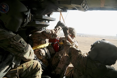 U.S. Army Capt. Ryan Stanfield, a flight nurse, and Sgt. Jared Belisle, a crew chief, both assigned to Company C, 1st General Support Aviation Battalion, 111th Aviation Regiment, Task Force Dragon, pull German soldiers into an HH-60M Black Hawk helicopter during a coalition medevac and hoist training exercise at Erbil, Iraq, Aug. 20, 2016. This training was conducted to teach and familiarize German, Dutch, and Finnish soldiers with U.S. Army medevac equipment and procedures. More than 60 Coalition partners have committed themselves to the goal of eliminating the threat posed by the Islamic State of Iraq and the Levant and have contributed in various capacities to the effort to combat ISIL.