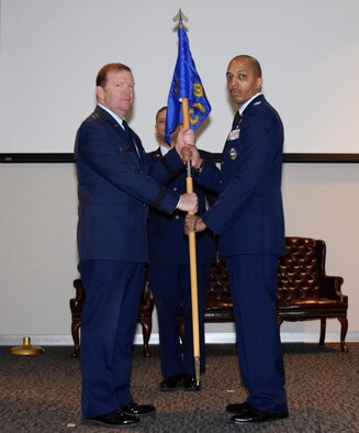 Maj. Gen. Richard Scobee, 10th Air Force commander, passes the 960th Cyberspace Operations Group flag to Col. Anthony Perkins during a change of command ceremony held Aug. 27 at the Inter-American Air Forces Academy at Joint Base San Antonio-Lackland, Texas. Perkins said his focus coming into this position is to "listen, learn and lead." (U.S. Air Force photo by Maj. Alysia R. Harvey) 
