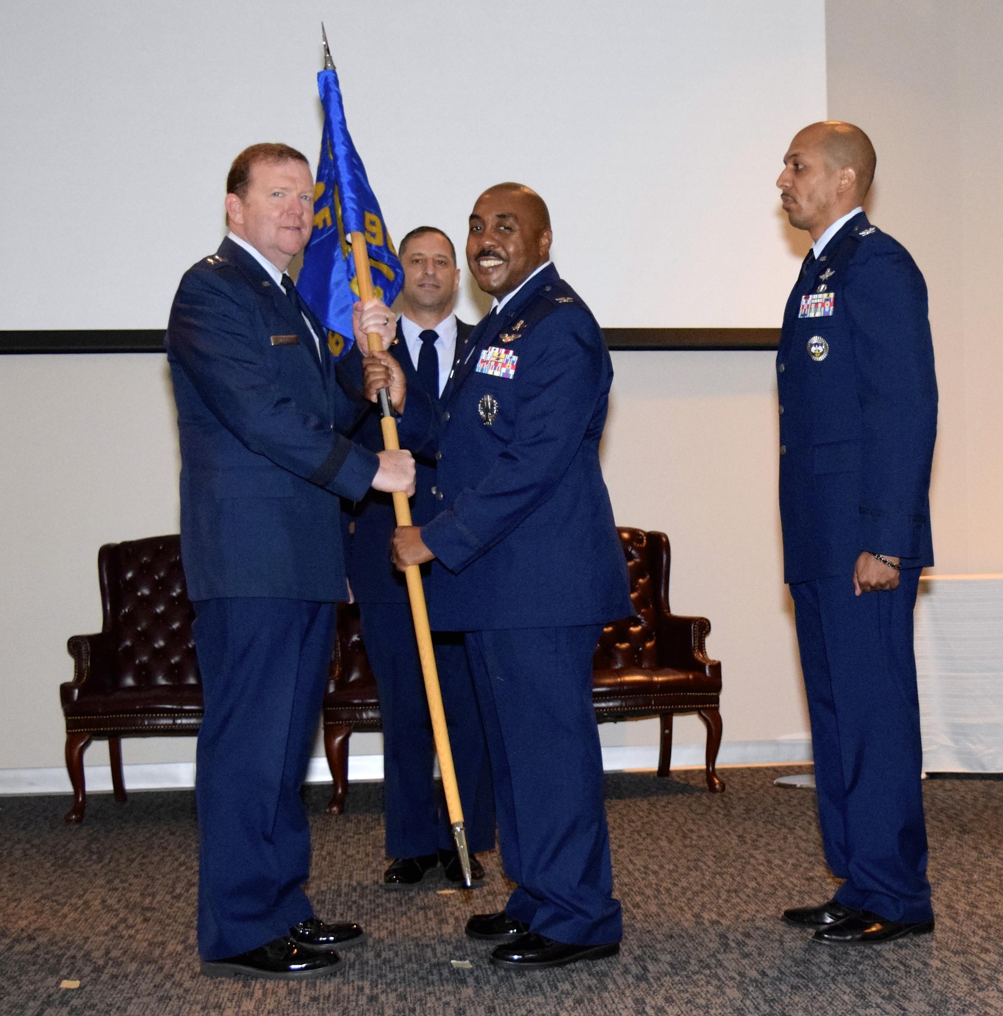 Maj. Gen. Richard Scobee, 10th Air Force commander, receives the 960th Cyberspace Operations Group flag from Col. Lloyd I. Terry, Jr. as Col. Anthony M. Perkins stands ready to receive it and assume command of the unit, while Chief Master Sgt. Thomas Africano, 960th CyOG superintendent looks on. Terry relinquished command after serving three years at the helm during a change of command ceremony held Aug. 27 at the Inter-American Air Forces Academy at Joint Base San Antonio-Lackland, Texas. (U.S. Air Force photo by Maj. Alysia R. Harvey) 