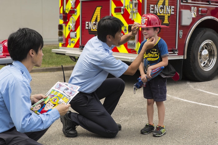 A student from Matthew C. Perry Elementary School receives a toy firefighting helmet during the Back to School Bash at Marine Corps Air Station Iwakuni, Japan, Aug. 26, 2016. This school year will mark the last first day of school for students at the old M.C. Perry buildings. (U.S. Marine Corps photo by Lance Cpl. Aaron Henson)