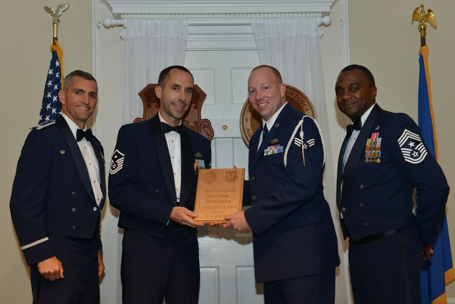 U.S. Air Force Senior Airman Patrick McElroy, 20th Equipment Maintenance Squadron, receives a distinguished graduate award for the Senior Master Sgt. David B. Reid Airman Leadership School Class 16-6 from Master Sgt. Robert Finton, 20th Operations Support Squadron first sergeant, at Shaw Air Force Base, S.C., Aug. 25, 2016. The distinguished graduate awards are given to the top 10 percent of the class for total point accumulation. (U.S. Air Force photo by Airman 1st Class Destinee Sweeney)