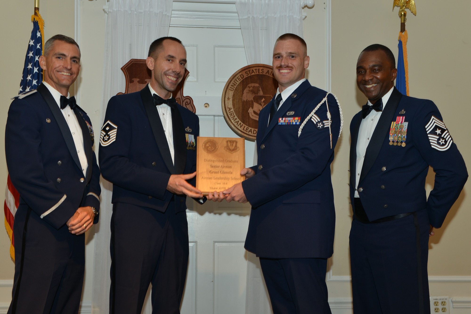 U.S. Air Force Senior Airman Grant Gianola, 367th Fighter Squadron, receives a distinguished graduate award for the Senior Master Sgt. David B. Reid Airman Leadership School Class 16-6 from Master Sgt. Robert Finton, 20th Operations Support Squadron first sergeant, at Shaw Air Force Base, S.C., Aug. 25, 2016. The distinguished graduate awards are given to the top 10 percent of the class for total point accumulation. (U.S. Air Force photo by Airman 1st Class Destinee Sweeney)