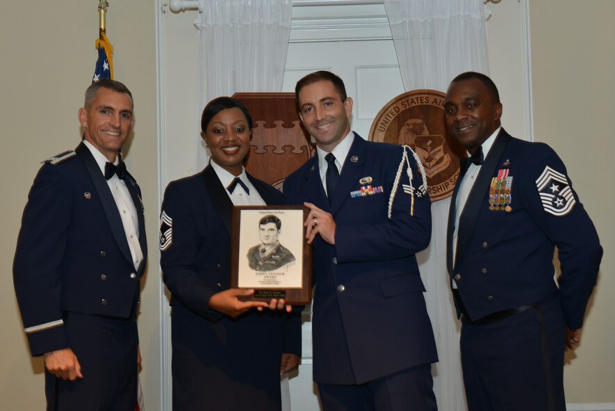 U.S. Air Force Senior Airman Brett Switzer, 31st Intelligence Squadron, receives the John L. Levitow Award for the Senior Master Sgt. David B. Reid Airman Leadership School Class 15-7, from Chief Master Sgt. Diena Mosely, 20th Medical Group superintendent, at Shaw Air Force Base, S.C., Aug. 25, 2016. The Levitow Award is given to the graduate with the highest average of instructor and student points, and is the highest award in enlisted professional military education. (U.S. Air Force photo by Airman 1st Class Destinee Sweeney) 