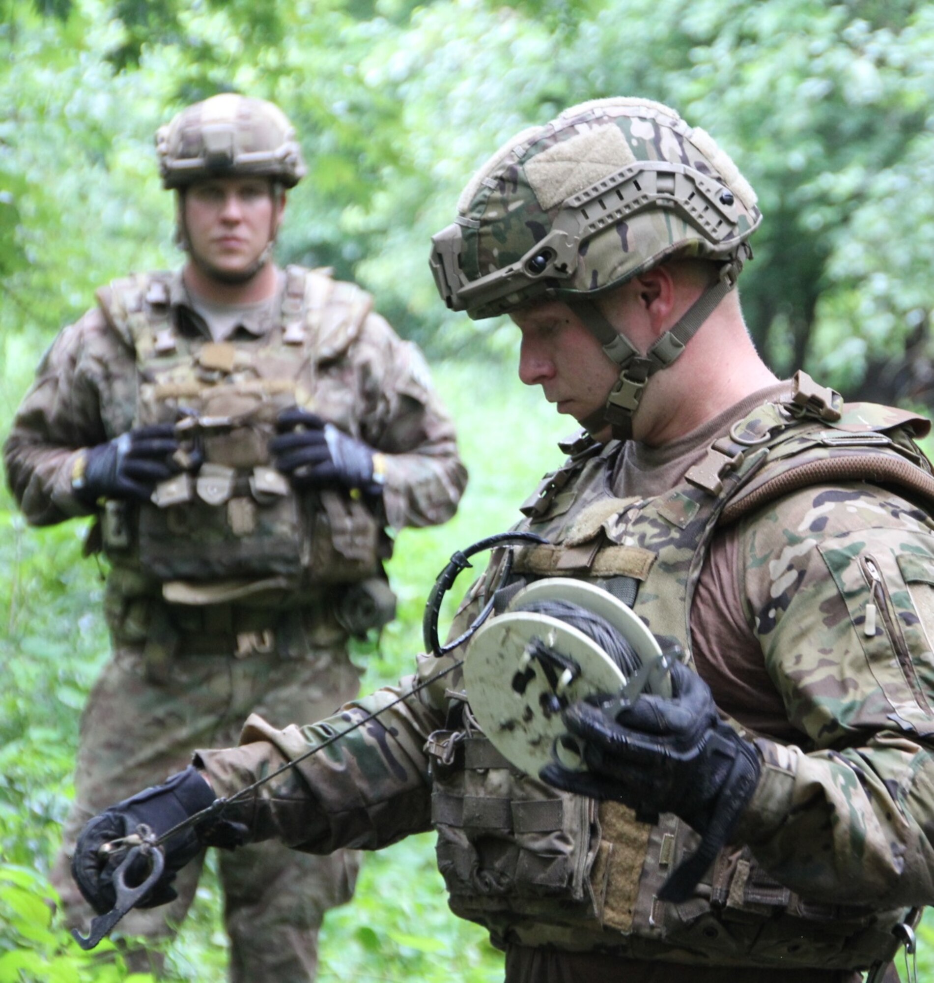 The 932nd Airlift Wing's Explosive Ordnance Disposal team members Tech. Sgt. Blake Witte (background) and Staff Sgt. Kody Bloodworth (holding gear),  prepare heavy duty string and clips to acquire their possible hazardous "target" and remove a potential explosive hazard, during a training scenario at Scott Air Force Base on August 13, 2016.  Airmen of the 932nd Civil Engineering Squadron battled the elements of rain, summer heat, humidity, and thick mud along with various bugs deep in the woods, but they managed their resources and kept squadron camaraderie high. They are part of the 932nd CES, utilized under 22nd Air Force, an Air Force Reserve Command unit.  (U.S. Air Force photo by Maj. Stan Paregien)