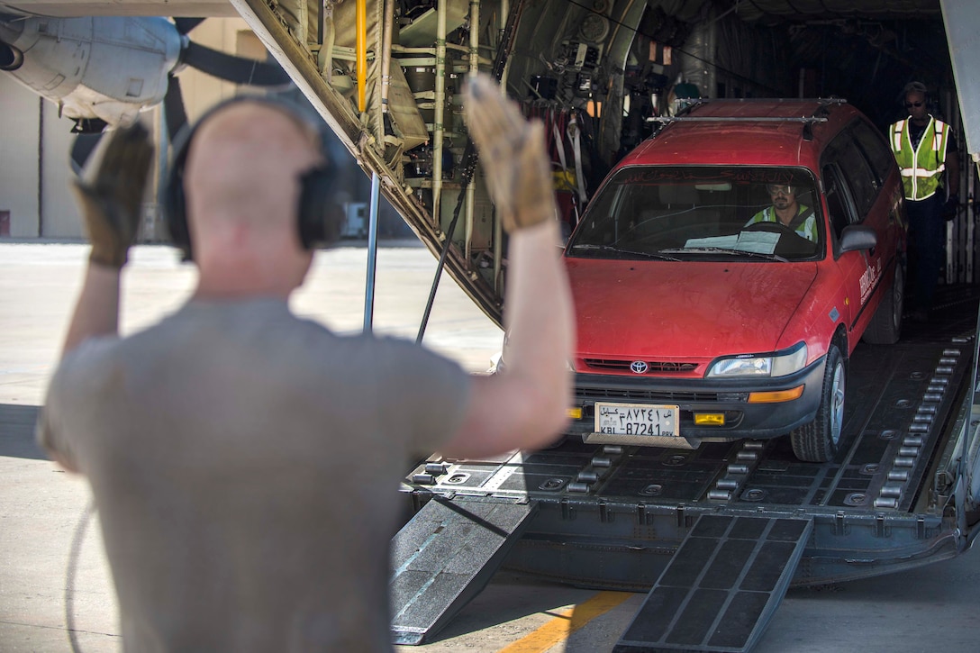 Air Force Senior Airman Andrew Garrett, foreground, uses hand signals directing a vehicle off a C-130J Super Hercules aircraft at Bagram Airfield, Afghanistan, Aug. 19, 2016. Garrett is a loadmaster assigned to the 774th Expeditionary Airlift Squadron. Air Force photo by Senior Airman Justyn M. Freeman