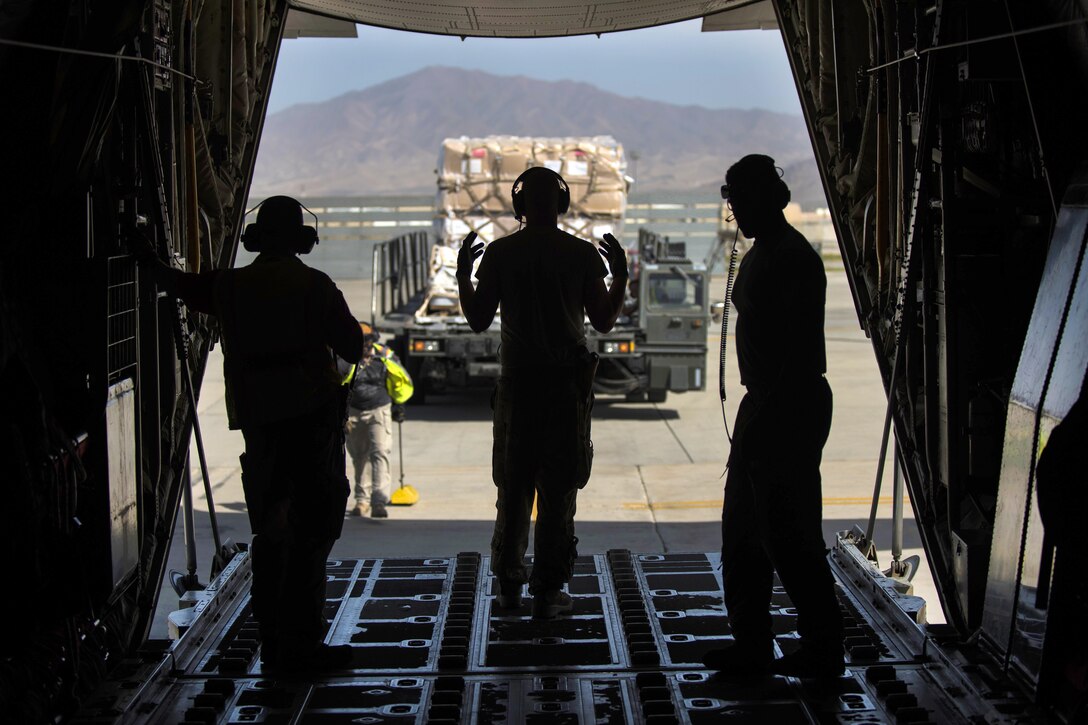 Air Force Senior Airman Andrew Garrett, center, uses hand signals to direct a vehicle off a C-130J Super Hercules aircraft at Bagram Airfield, Afghanistan, Aug. 19, 2016. Garrett is assigned to the 774th Expeditionary Airlift Squadron. Air Force photo by Senior Airman Justyn M. Freeman 