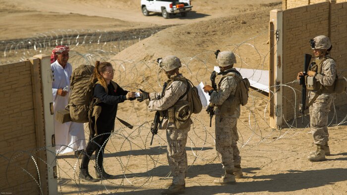Marines with Special Purpose Marine Air Ground Task Force, Crisis Response, Central Command, check role-players ID cards before screening them during a non-combatant evacuation operation exercise at Range 220, a military operations on urbanized terrain facility, at Marine Corps Air Ground Combat Center, Twentynine Palms, Calif., Aug. 24, as part of a Certification Exercise.