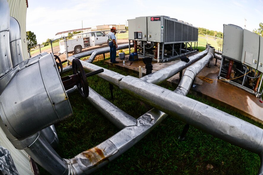 Jimmy Beattie, 2nd Civil Engineer Squadron heating ventilation and air condition civilian, and Senior Airman Brittany Parks, 2nd CES HVAC Technician, drain refrigerant from an air conditioning unit at Barksdale Air Force Base, La., Aug. 23, 2016. They are draining the line so that a compressor can be replaced in one of the units. (U.S. Air Force photo/Senior Airman Luke Hill)